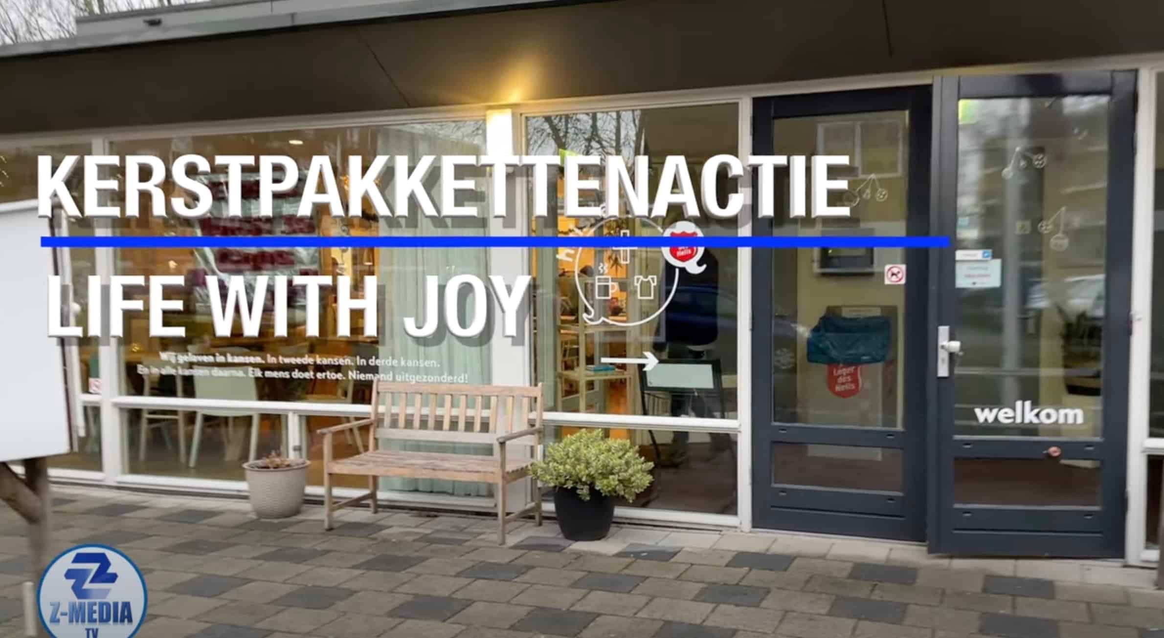 Etalage met een banner voor de Kerstpakkettenactie van Life With Joy