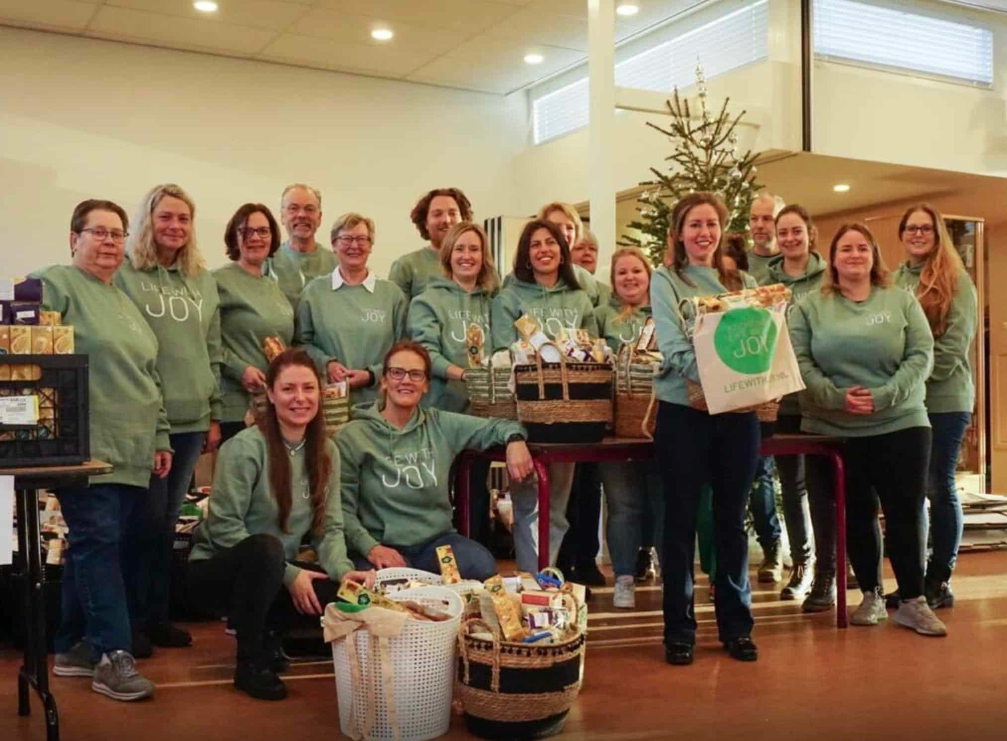 Vrijwilligers in groene Life With Joy-truien bij de samengestelde pakketten